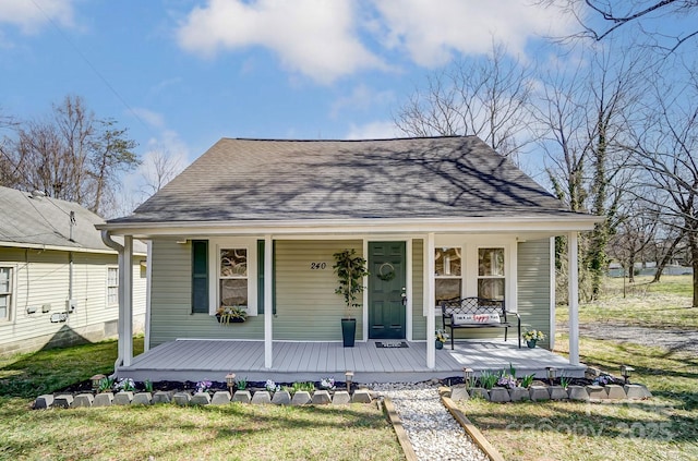 bungalow-style home with a porch and a shingled roof