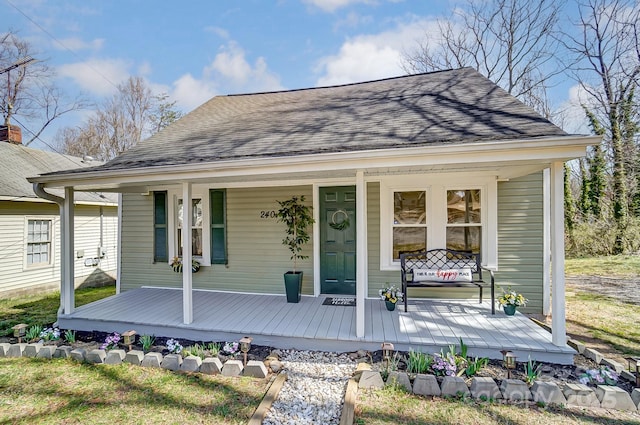 exterior space with covered porch and a shingled roof