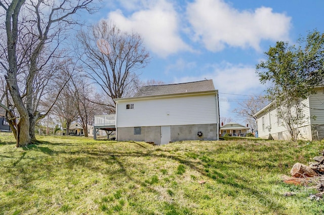 rear view of house with a deck and a lawn