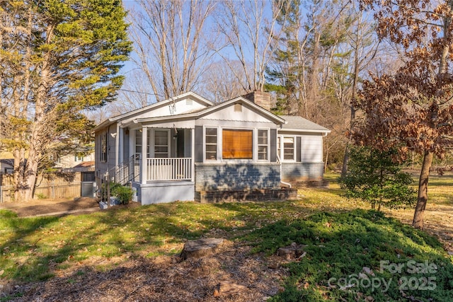 bungalow-style house with a chimney, a front yard, and fence