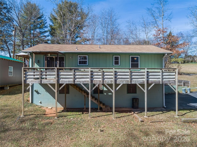 back of house featuring stairs, a lawn, and a wooden deck