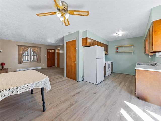 kitchen with brown cabinetry, a baseboard radiator, white appliances, and light countertops