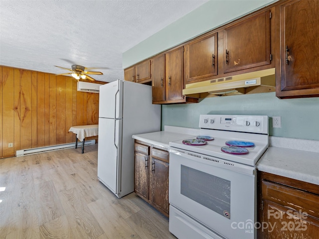 kitchen with under cabinet range hood, white appliances, light wood-style floors, light countertops, and baseboard heating