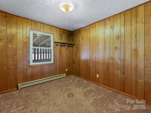 carpeted empty room featuring a textured ceiling, a baseboard radiator, and wooden walls