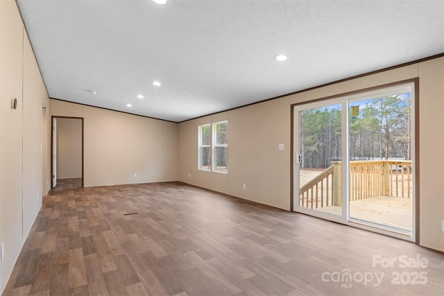 unfurnished room featuring a textured ceiling, wood finished floors, and recessed lighting