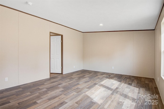 unfurnished room with crown molding and wood finished floors