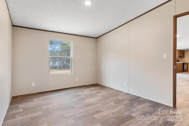 unfurnished room with crown molding, light wood-style flooring, and a textured ceiling