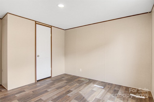 unfurnished room with ornamental molding, recessed lighting, and wood finished floors