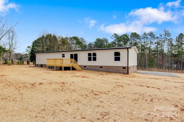 view of front of house with crawl space and a deck