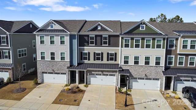 view of property with stone siding, a standing seam roof, metal roof, and driveway