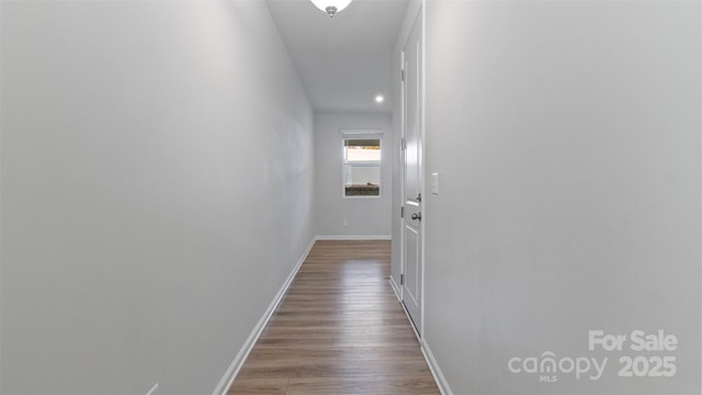 hall with light wood-type flooring and baseboards