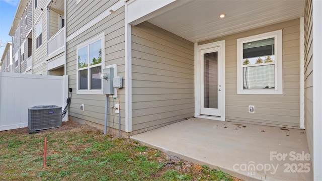 doorway to property with a patio area, fence, and central air condition unit