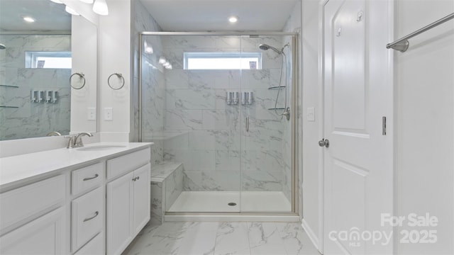 bathroom with marble finish floor, a healthy amount of sunlight, vanity, and a marble finish shower