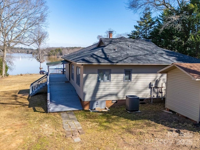 view of home's exterior with central AC, a water view, a yard, crawl space, and roof with shingles