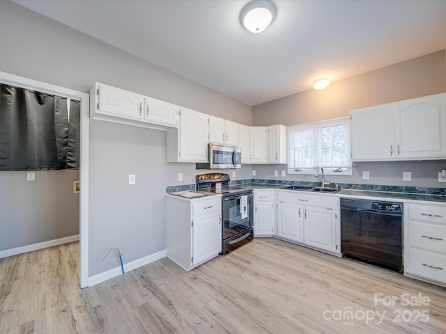 kitchen featuring a sink, baseboards, light wood-style floors, white cabinets, and black appliances