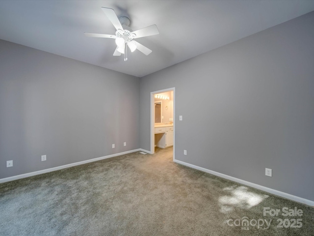 unfurnished bedroom with carpet floors, connected bathroom, baseboards, and a ceiling fan