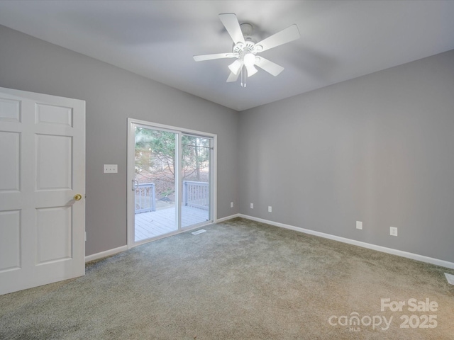 empty room featuring visible vents, carpet, a ceiling fan, and baseboards