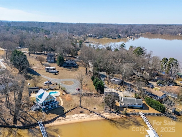 aerial view with a water view and a wooded view