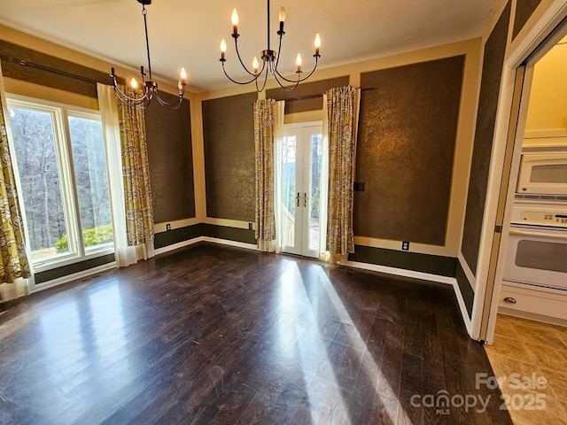 unfurnished dining area featuring dark wood-style floors, french doors, and a healthy amount of sunlight