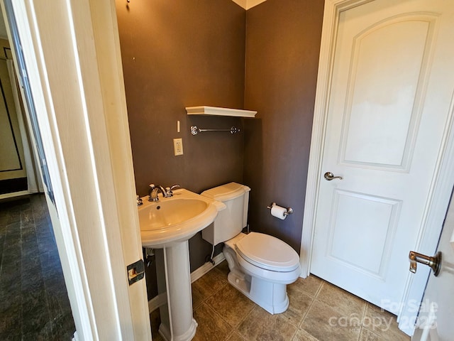 bathroom with a sink, tile patterned flooring, toilet, and baseboards