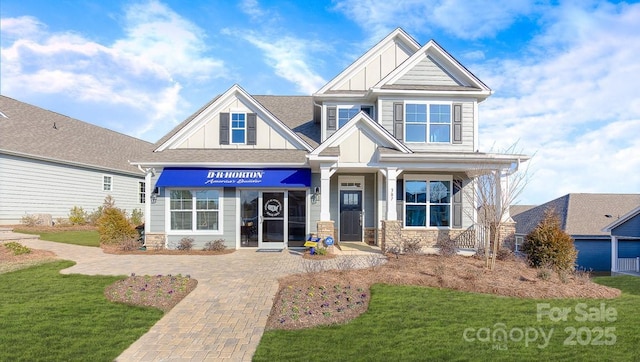 craftsman-style home featuring a front lawn and board and batten siding