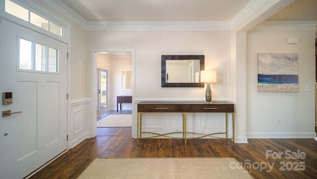 foyer with baseboards, ornamental molding, and dark wood finished floors