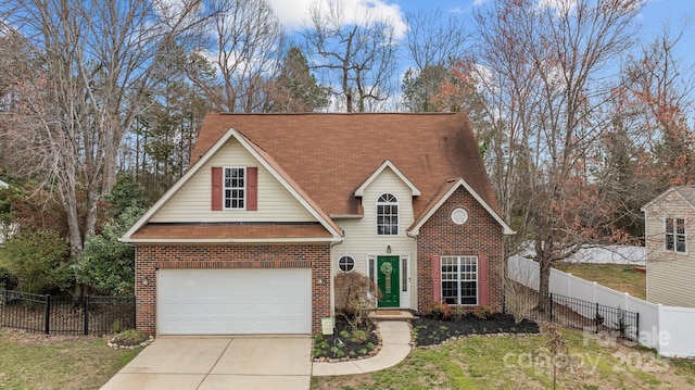 traditional-style house featuring brick siding, concrete driveway, and fence