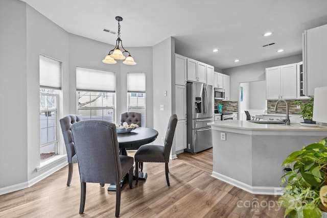 dining space featuring light wood-style flooring, recessed lighting, and visible vents