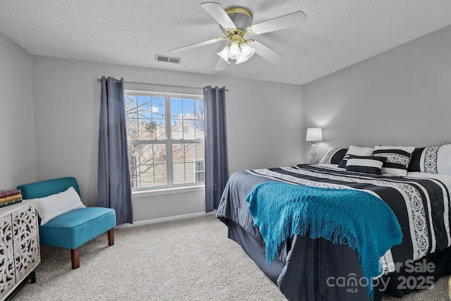 carpeted bedroom with a ceiling fan, baseboards, visible vents, and a textured ceiling