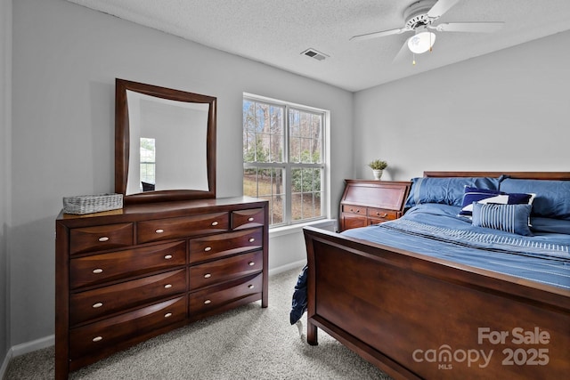 bedroom featuring visible vents, light colored carpet, a textured ceiling, and baseboards