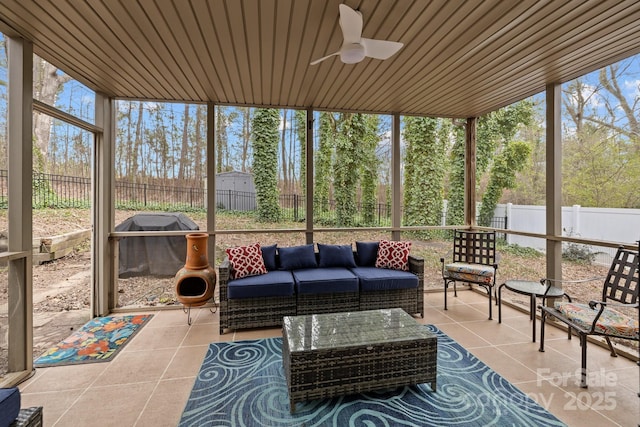 sunroom with ceiling fan and wooden ceiling