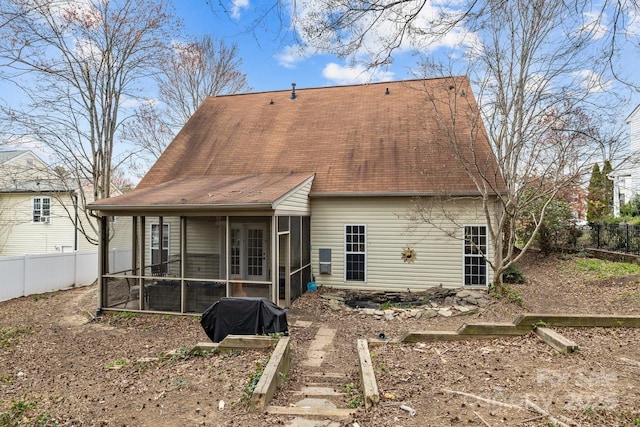 back of house with a fenced backyard and a sunroom