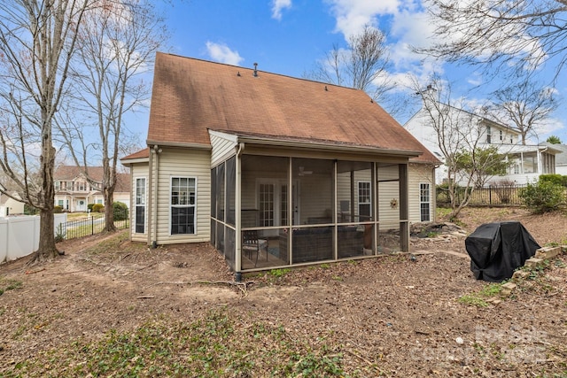 rear view of property with fence and a sunroom