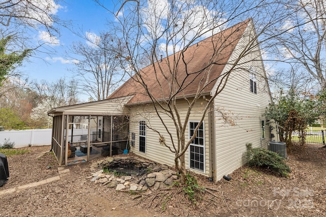 back of house with central AC, fence, a sunroom, and a shingled roof