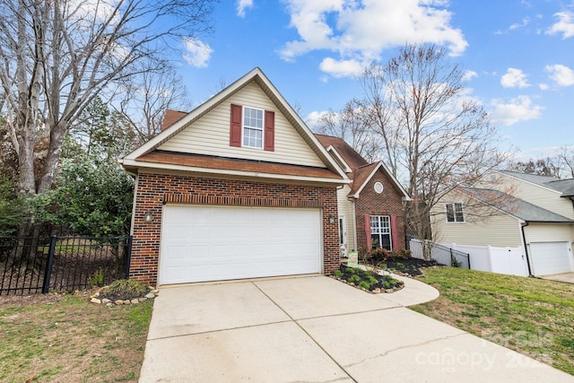 traditional-style house with brick siding, concrete driveway, a front lawn, and fence