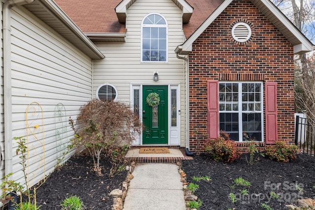 entrance to property with a shingled roof