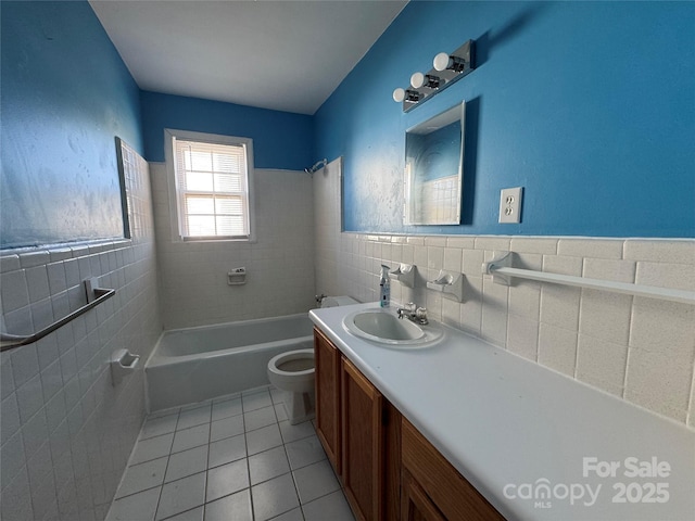 bathroom with vanity, wainscoting, tile walls, toilet, and tile patterned floors