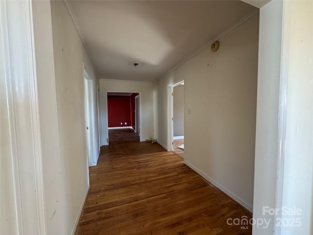 hallway with baseboards, dark wood finished floors, and ornamental molding