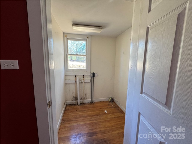 laundry area featuring laundry area, wood finished floors, and baseboards