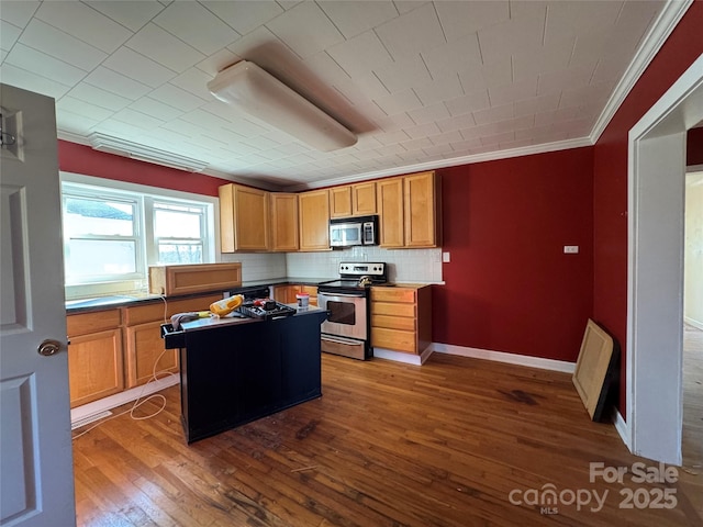 kitchen with a kitchen island, crown molding, decorative backsplash, appliances with stainless steel finishes, and dark wood-style floors