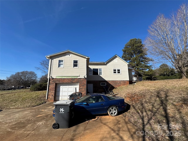 view of front facade with brick siding, driveway, and an attached garage