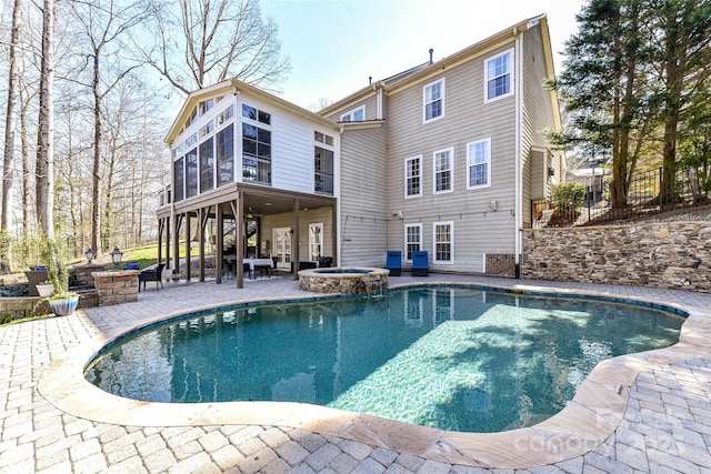 view of swimming pool with a sunroom, a patio, a fire pit, and fence