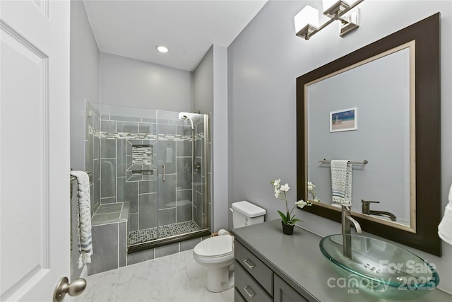 bathroom featuring marble finish floor, recessed lighting, toilet, a stall shower, and vanity