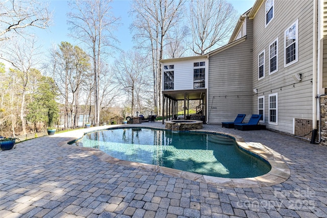 view of swimming pool featuring a pool with connected hot tub and a patio