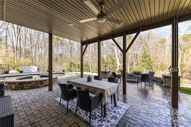 view of patio / terrace with an outdoor fire pit, outdoor dining area, an in ground hot tub, a ceiling fan, and an outdoor pool