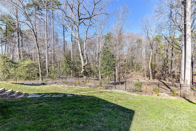 view of yard with a forest view and fence