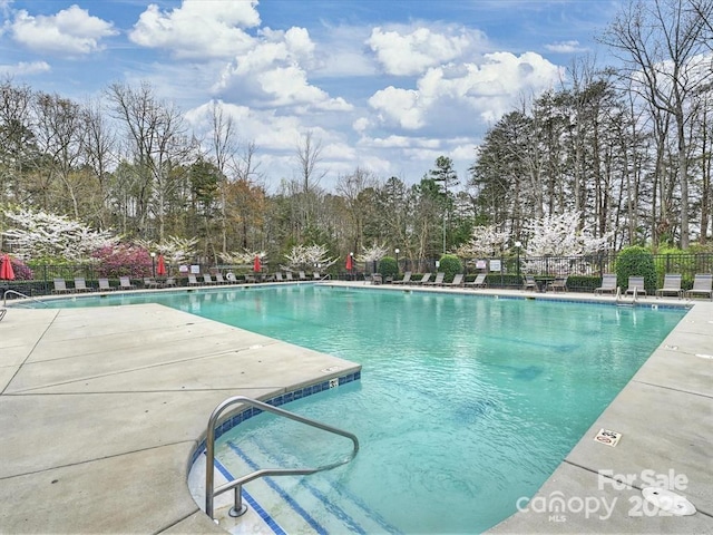 pool with a patio and fence