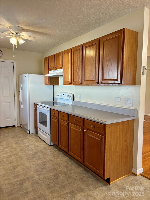 kitchen featuring light countertops, white appliances, brown cabinetry, and under cabinet range hood