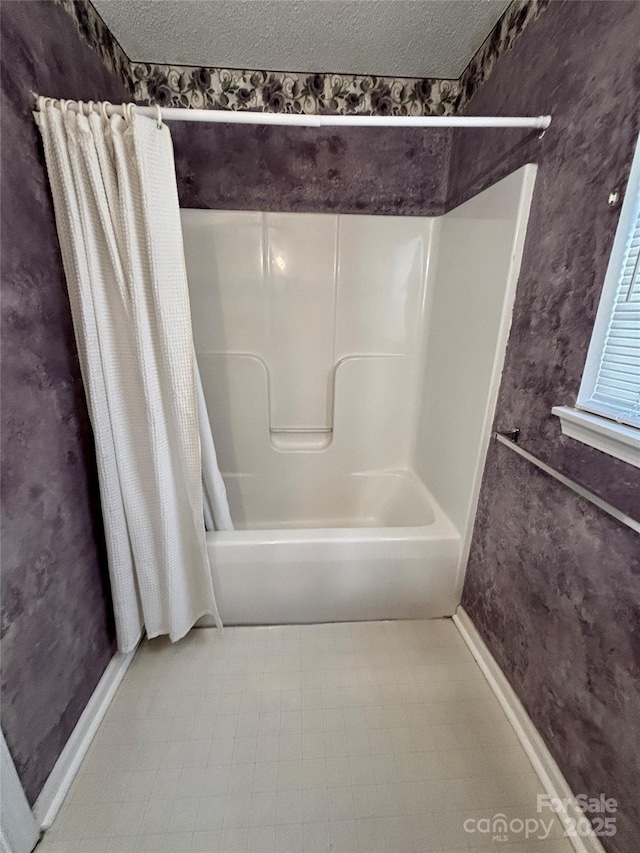 full bathroom with shower / bathtub combination with curtain, a textured ceiling, and tile patterned floors