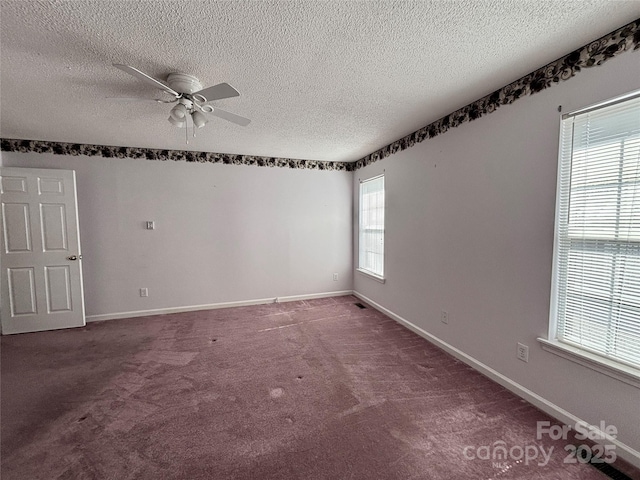 carpeted spare room featuring a ceiling fan, a textured ceiling, and baseboards